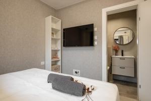 a bedroom with a bed with a tv on the wall at city center apartment in Jerusalem