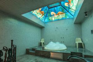 聖保羅的住宿－Motel Disco Verde Congonhas 4，带浴缸的浴室和彩色玻璃窗