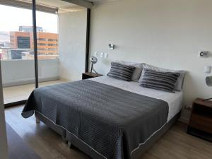een slaapkamer met een groot bed en een groot raam bij Distrito de lujo Departamento in Santiago