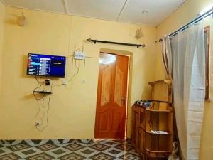 Zimmer mit einer Tür und einem TV an der Wand in der Unterkunft Villa meublée de saaba in Dassasgo