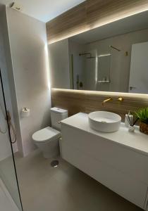 a bathroom with a sink and a toilet and a mirror at Palace Residence - Habitación en apartamento in Granada