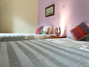 two beds in a room with pink walls at Posada Las Bromelias in Silvania