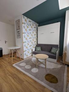 ein Wohnzimmer mit einem Sofa und einem Tisch in der Unterkunft Le Green Moderne centre ville parking gratuit in Montluçon