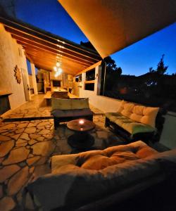 a living room with couches and a table on a patio at Casa del Sole Irgoli - BIKERS HOME in Irgoli