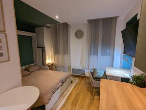 Schlafzimmer mit einem Bett, einem Schreibtisch und einem Tisch in der Unterkunft Le Green Moderne centre ville parking gratuit in Montluçon