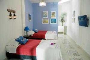 two beds in a room with blue and white at Posada Las Bromelias in Silvania