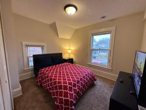 a bedroom with a red bed and two windows at Lyndale Oasis in Minneapolis