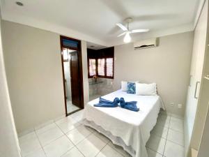a bedroom with a bed with a blue ribbon on it at Casa Cantinho do Girassol in Natal +28 photos