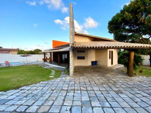 a house with a brick driveway in front of it at Casa Cantinho do Girassol in Natal