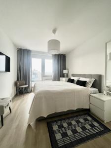 a white bedroom with a large bed and a window at VP Suites in Budapest