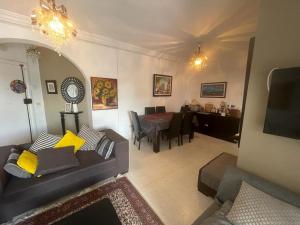a living room with a couch and a dining room at APPART SARAH Plage in Hammamet Nord