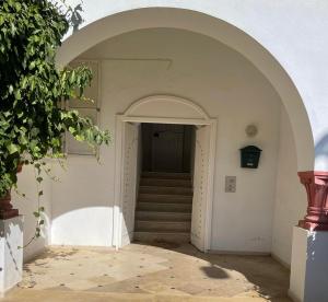 an archway leading to a hallway with a staircase at APPART SARAH Plage in Hammamet Nord