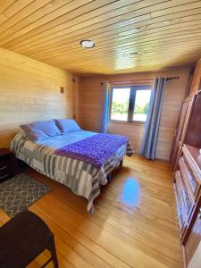 a bedroom with a bed in a wooden room at Casa Tauco in Rauco