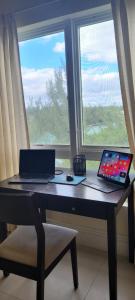 uma secretária com um computador portátil e um tablet em Gated waterfront condo with boat dock and view em Freeport