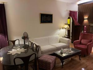 - un salon avec un canapé, une table et des chaises dans l'établissement Wonderful Apartment Place in Dokki, au Caire