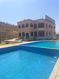 une grande piscine en face d'un bâtiment dans l'établissement Maison d'Hôte - Le Beau Panorama, à Berkane