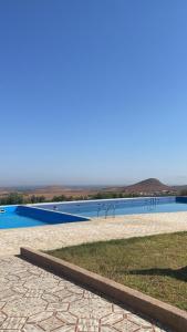 une piscine d'eau bleue en arrière-plan dans l'établissement Maison d'Hôte - Le Beau Panorama, à Berkane