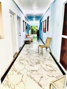 a hallway with a marble floor and a chair at Neo’s hotel in Santa Cruz de Barahona