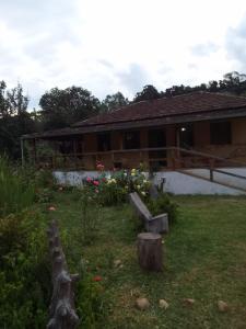 una casa con un patio con un banco y flores en Chalé anjico, en Aiuruoca