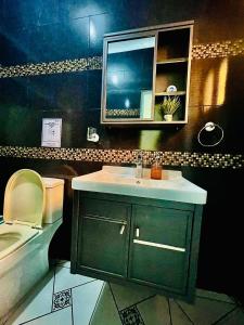 uma casa de banho com um lavatório, um WC e um espelho. em Neo’s hotel em Santa Cruz de Barahona