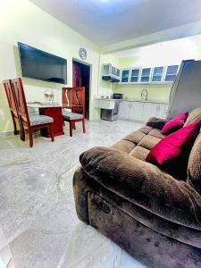 a living room with a couch and a kitchen at Neo’s hotel in Santa Cruz de Barahona