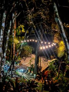 Tienda de campaña con luces en un jardín por la noche en Cabañas Lago Cerro Azul - Lake of Panama, en Cerro Azul