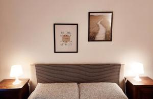 a bedroom with two pictures above a bed and two lamps at The Smart Choice Apartments in Florence