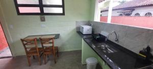 a kitchen with two chairs and a counter with a sink at Morro do Forte in Guarujá