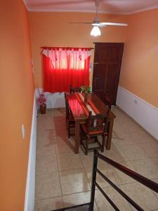 um quarto com uma mesa e cadeiras e uma cortina vermelha em Nuevo Amanecer en San Fdo del Valle de Catamarca em San Fernando del Valle de Catamarca