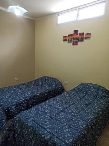 um quarto com uma cama com lençóis azuis e uma janela em Nuevo Amanecer en San Fdo del Valle de Catamarca em San Fernando del Valle de Catamarca