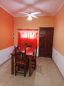 a dining room with a red table and a ceiling fan at Nuevo Amanecer en San Fdo del Valle de Catamarca in San Fernando del Valle de Catamarca