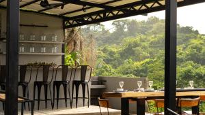 een tafel en stoelen op een patio met uitzicht bij Casa Xue Tayrona - Alma Hotels in Los Naranjos