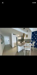 a kitchen with two white chairs and a table at OCEANFRONT LUXURY IN JUAN DOLIO in Juan Dolio