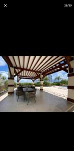 a pavilion with tables and chairs under a roof at OCEANFRONT LUXURY IN JUAN DOLIO in Juan Dolio