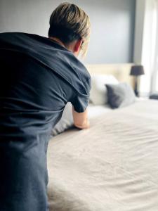 a man is standing next to a bed at Seaport Apartment STUDIO Austral 401 in Ushuaia