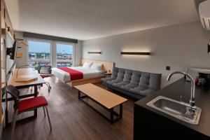 une chambre d'hôtel avec un lit et un canapé dans l'établissement City Express by Marriott EBC Reforma, à Mexico