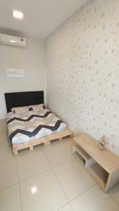een kleine slaapkamer met een bed en een houten bank bij Modern & Homely CBD Private Suite with Pool & Gym in Petaling Jaya