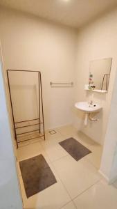 een witte badkamer met een wastafel en een spiegel bij Modern & Homely CBD Private Suite with Pool & Gym in Petaling Jaya