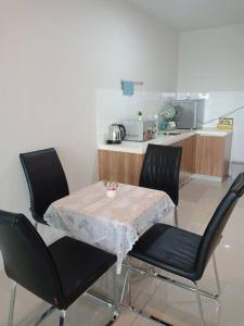 een tafel en stoelen met een keuken in een kamer bij Modern & Homely CBD Private Suite with Pool & Gym in Petaling Jaya