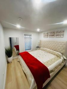 1 dormitorio con 1 cama grande con manta roja en Holiday home with all season Swim spa & Pond view en Londres