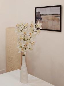 a white vase with white flowers on a table at The Smart Choice Apartments in Florence
