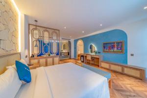 een slaapkamer met een groot bed en een blauwe muur bij V Boutique Hotel - Complimentary refreshments in Vung Tau