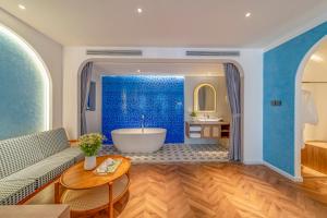 a bathroom with a tub and a blue wall at V Boutique Hotel - Complimentary refreshments in Vung Tau