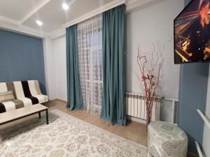 sala de estar con cortinas verdes y sofá en Однокомнатные апартаменты в золотом квадрате ЖК GREEN PLAZA en Aktau