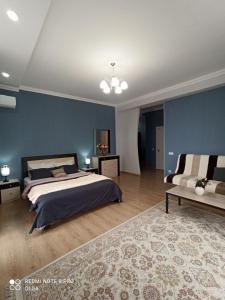 1 dormitorio con cama y pared azul en Однокомнатные апартаменты в золотом квадрате ЖК GREEN PLAZA en Aktau