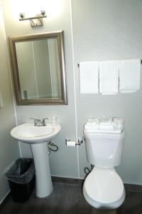 a bathroom with a toilet and a sink and a mirror at Best Motel in Seattle