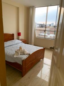 a bedroom with a bed and a large window at Central boutique Trujillo in Trujillo