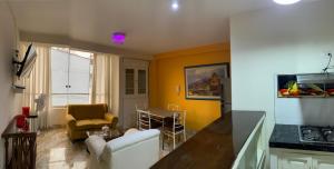 a living room with a white couch and a yellow wall at Central boutique Trujillo in Trujillo