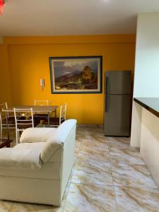 ein Wohnzimmer mit einem Kühlschrank und einem Tisch in der Unterkunft Central boutique Trujillo in Trujillo