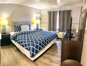 a bedroom with a blue and white bed and a window at Best Motel in Seattle